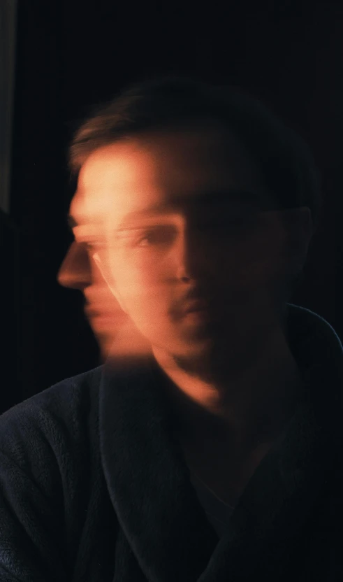 a man looks at a phone while in a dark room