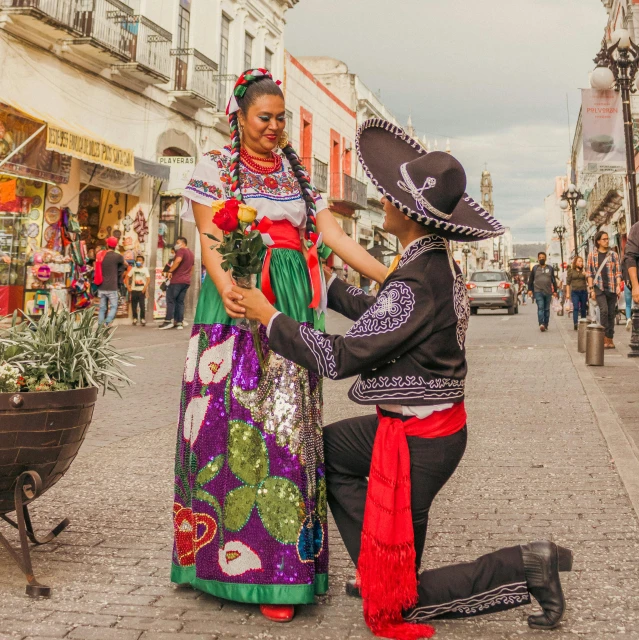 a woman in a mexican themed costume standing next to a man