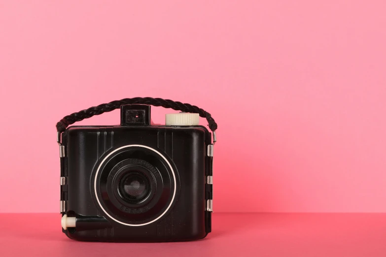 a camera on a pink surface with the image of an animal