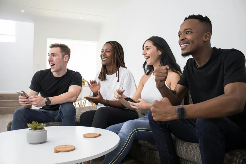 three adults and two children sitting on couch with one pointing towards a camera