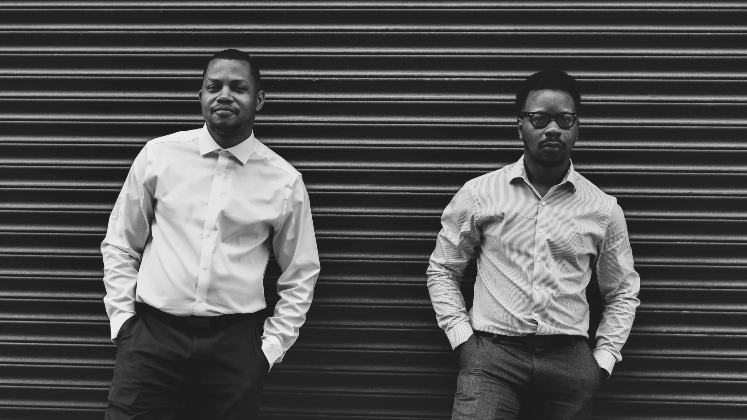 two men standing in front of a metal door