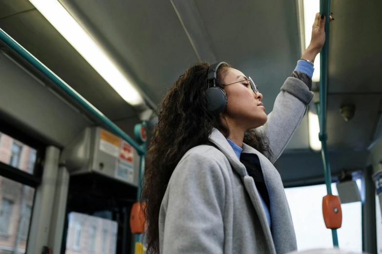 a woman wearing headphones is traveling on the bus