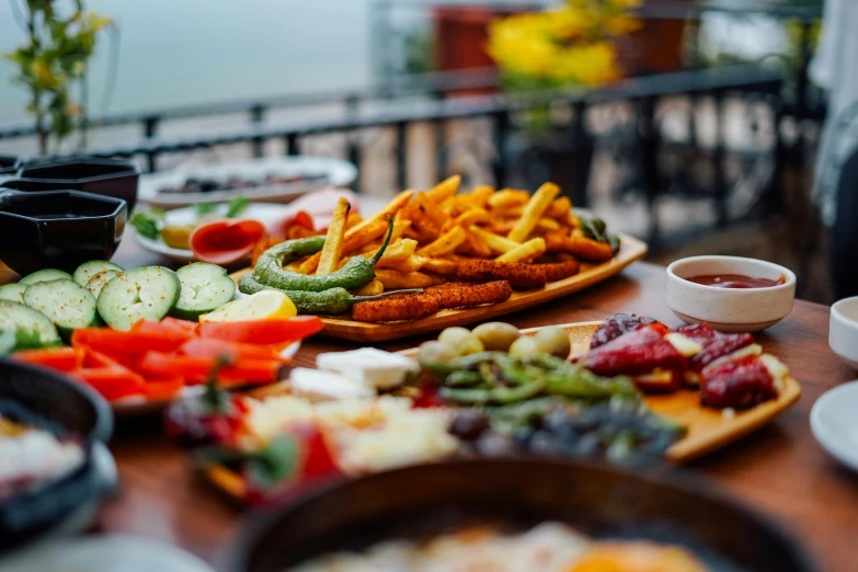 plates and trays of different kinds of food on table