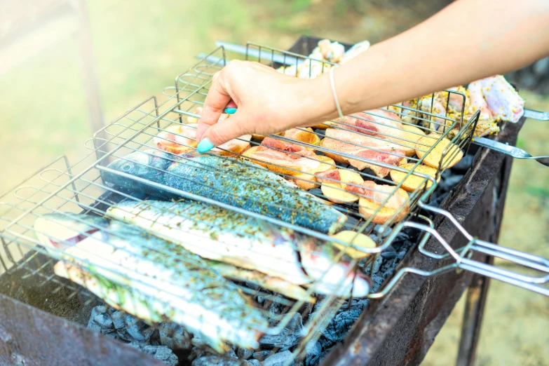 someone is cooking on an outdoor grill covered in food