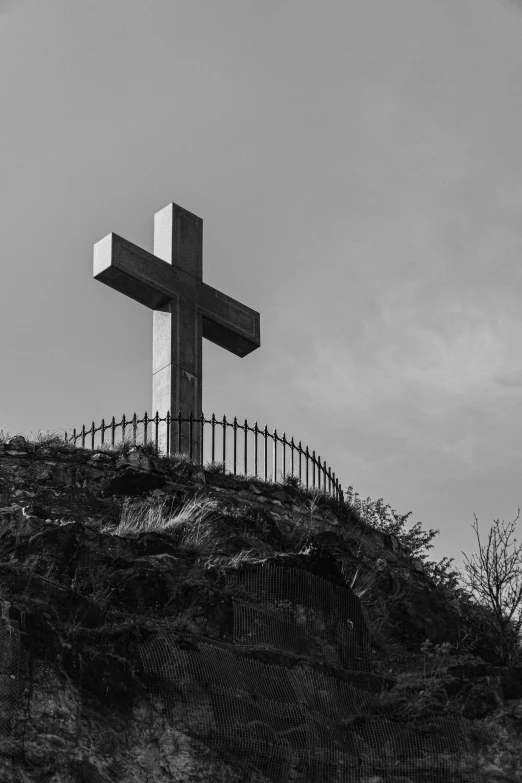 black and white po of a cross atop a mountain