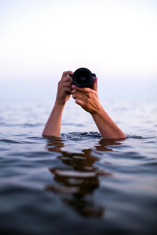 someone holding up their camera while in the water