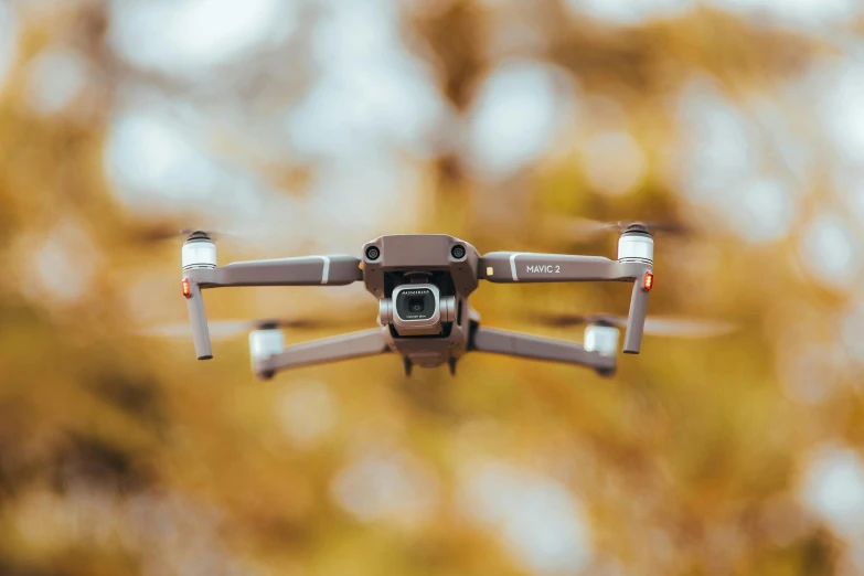 a small grey quad camera flying in the air