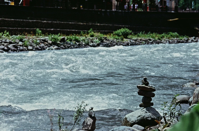 a pile of rocks on top of each other on the river bank