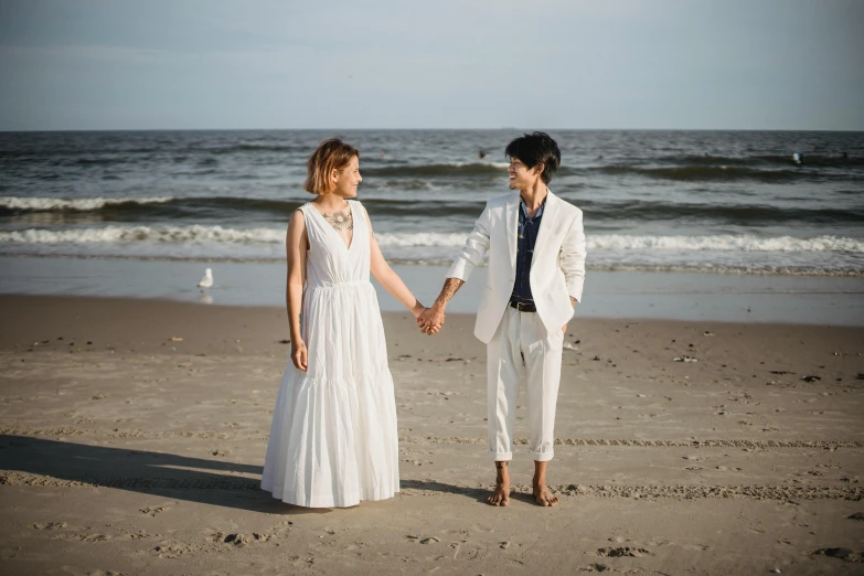 the young man and woman are dressed up holding hands