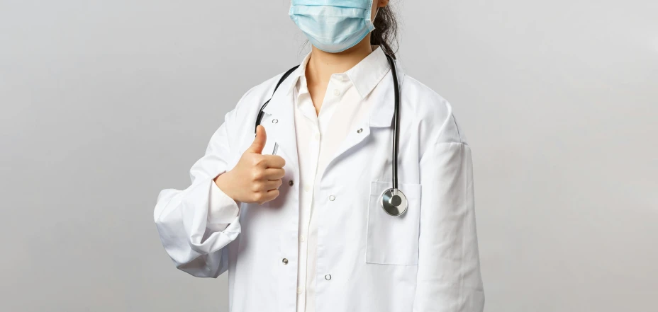 woman doctor with surgical mask giving thumbs up