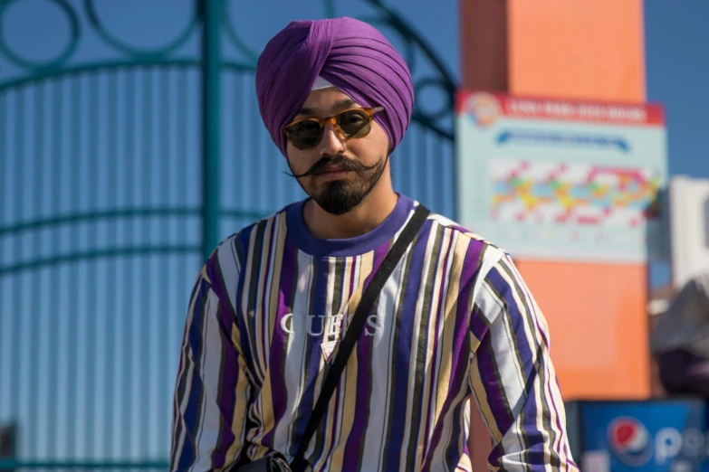 man with purple turban and sunglasses looking at camera