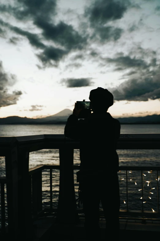 a man standing on top of a bridge looking at the water