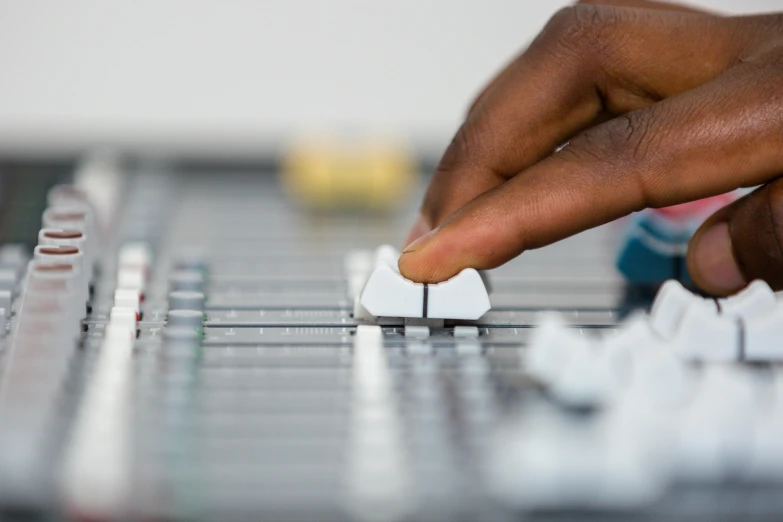 hands touching an item over a keyboard with a blurry background