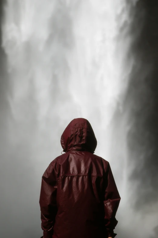 man in red jacket in the rain under a cloudy sky