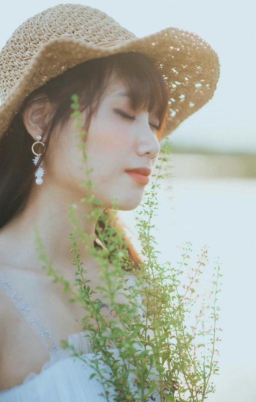 a girl wearing a hat and ear ring looking down