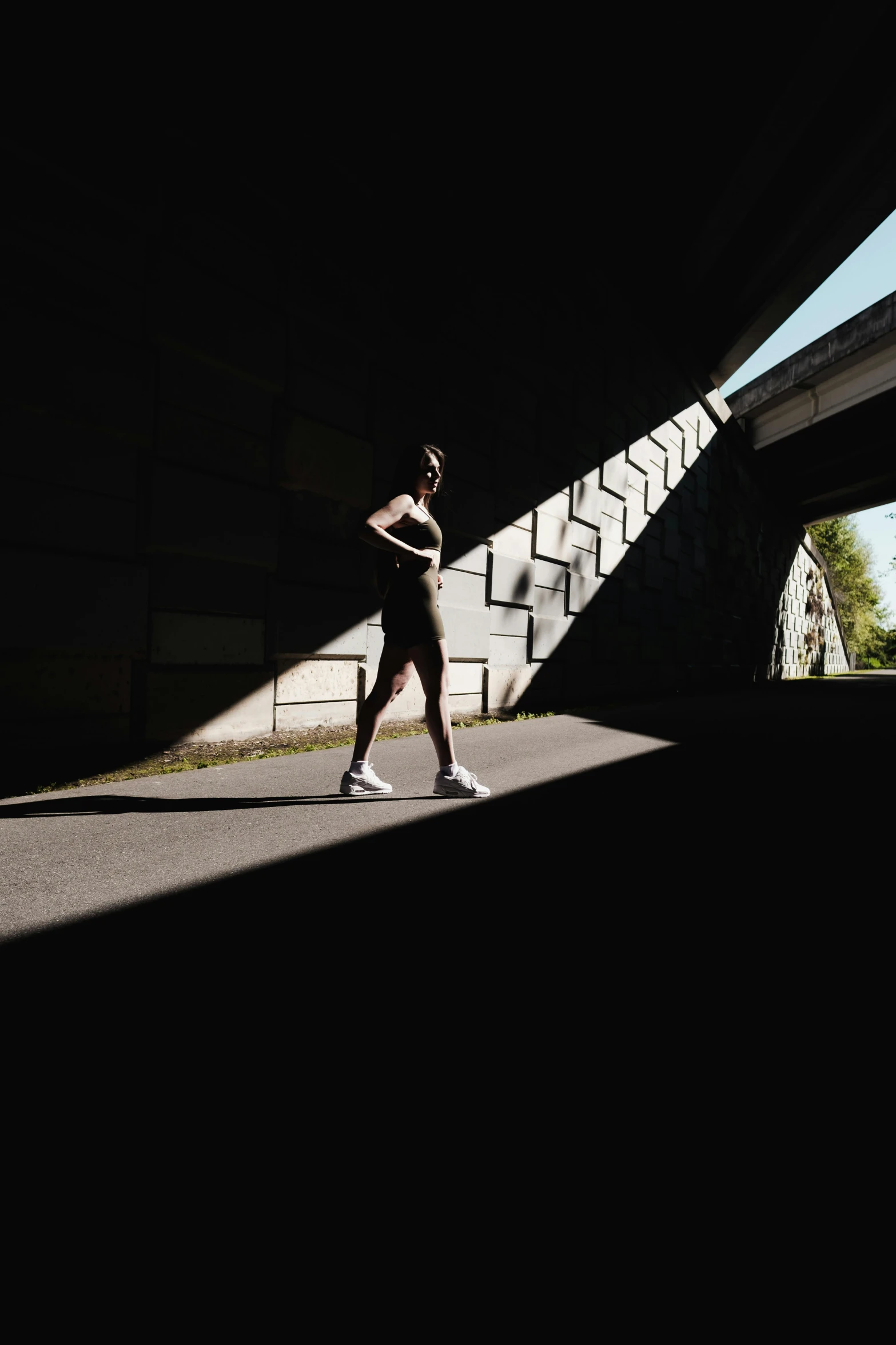 a woman jogging alone under the highway