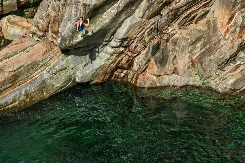 people standing on the rocks of a cliff overlooking water