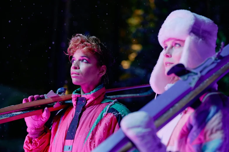 two women holding ski poles on a stage