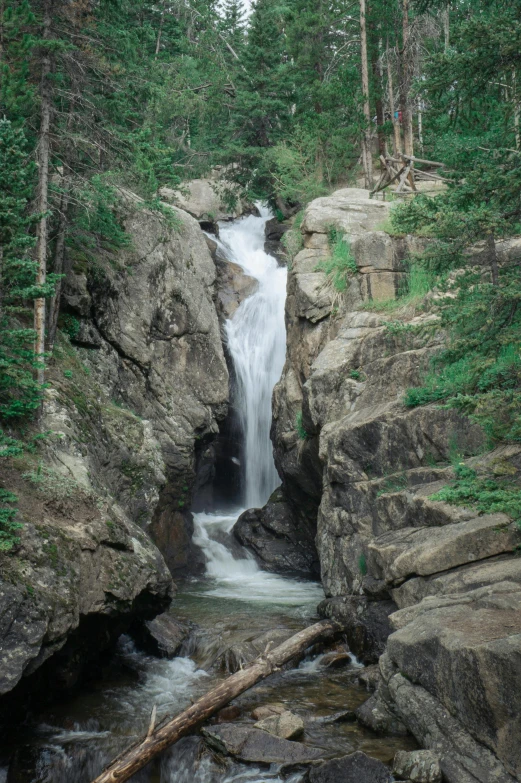 a waterfall runs into a rocky mountain stream