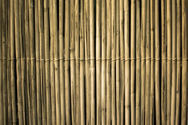 a brown and black clock next to a bamboo fence