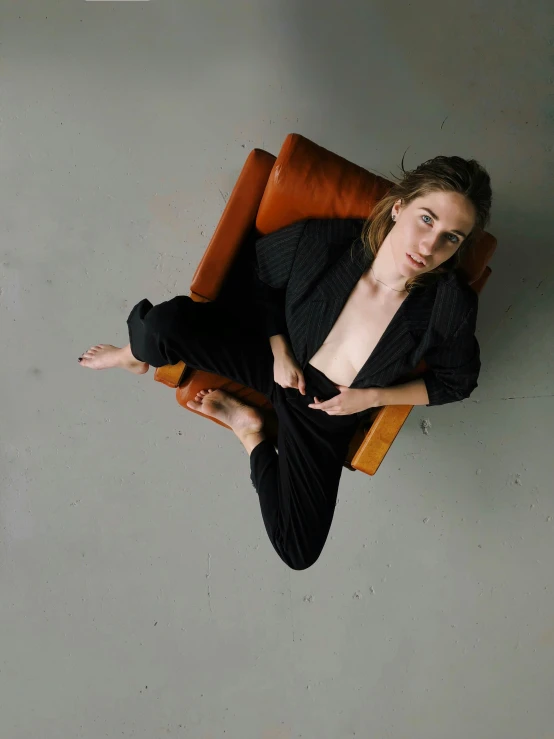 a woman sitting in an orange chair posing for a picture