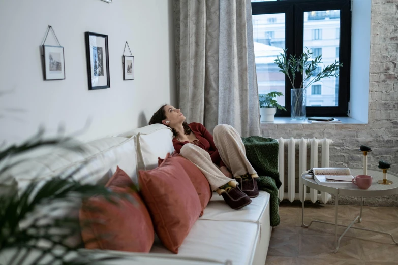 a young person laying on the sofa with their eyes closed