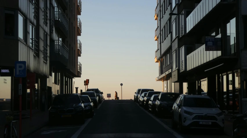 a long narrow street with cars parked on the side