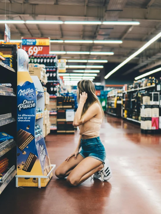 woman sitting on floor in store and talking on phone