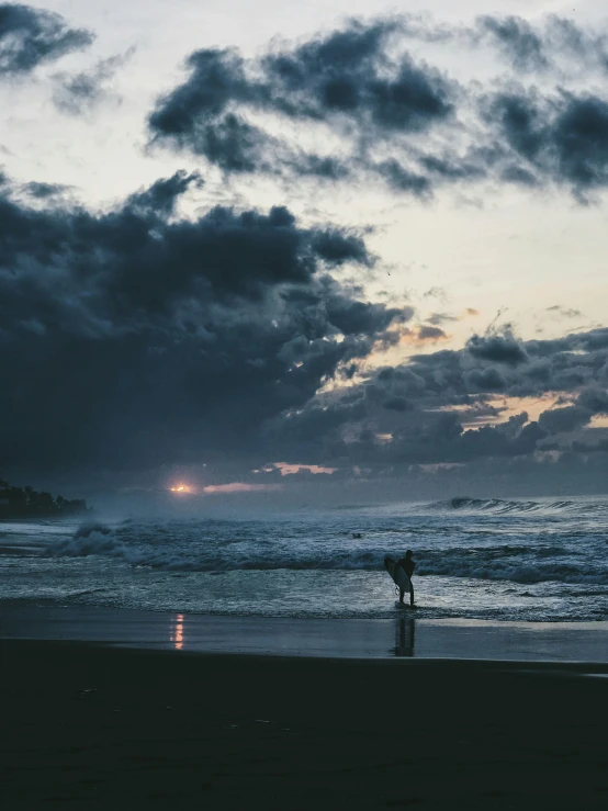 a person walking on the shore of a beach