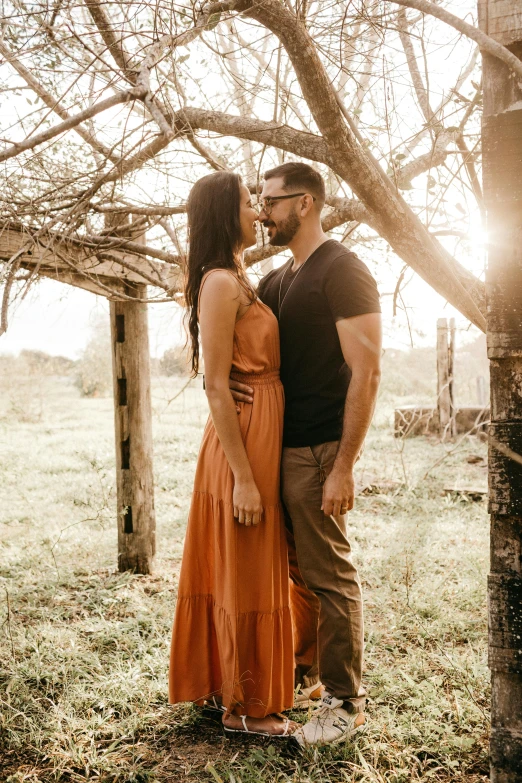 a man standing next to a woman near a tree