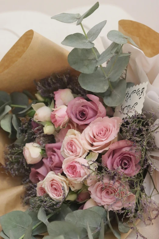 a bouquet of flowers and greenery sits on a table