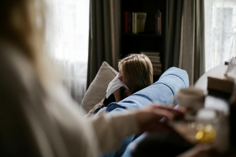 the woman is lying on the couch near the bookshelf