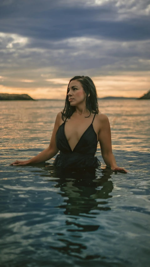 a beautiful young woman sitting on the water