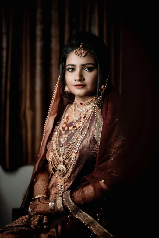 woman in saree sitting down, ready to be pographed