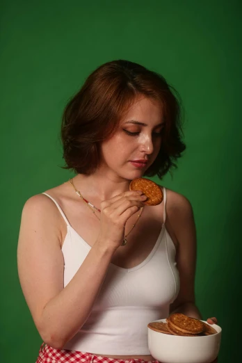woman eating a piece of doughnut from a bowl