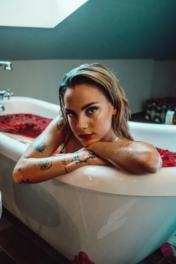 a woman posing in an ornate bathtub filled with red powder
