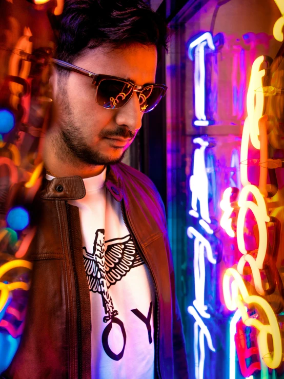 man with sunglasses in front of neon display