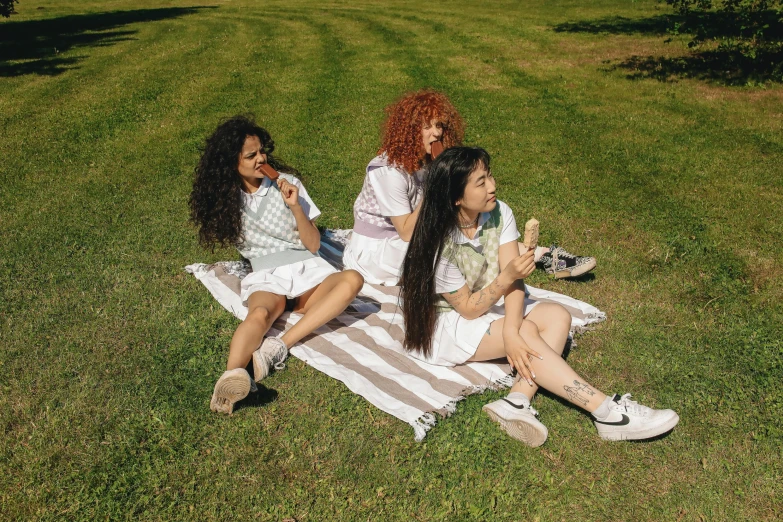 three girls sitting on the grass