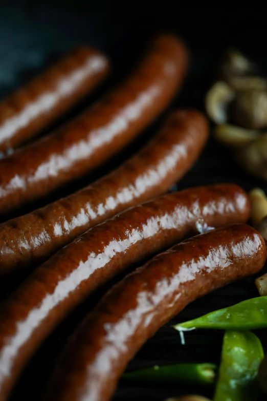 some sausages on the grill next to mushrooms