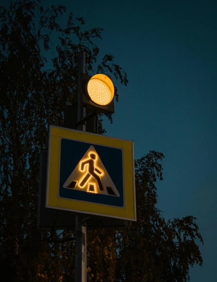 the pedestrian walk sign is lit up at night