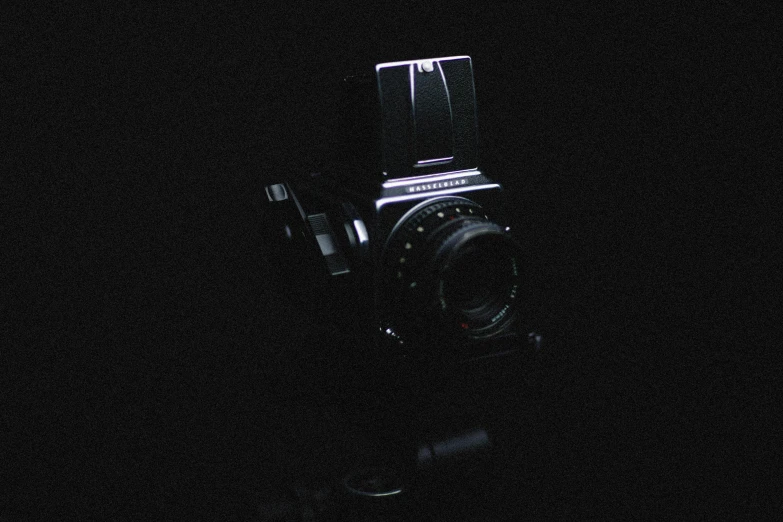 an old - fashioned camera sits empty in the dark