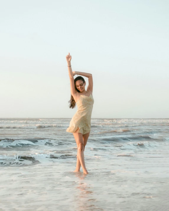 a beautiful young woman dancing on the beach