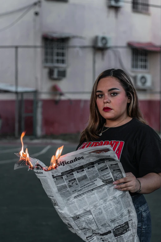 a girl is holding a paper and flames