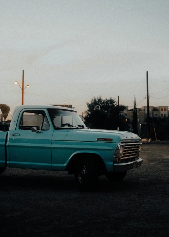 a bright blue pickup truck sits on the road