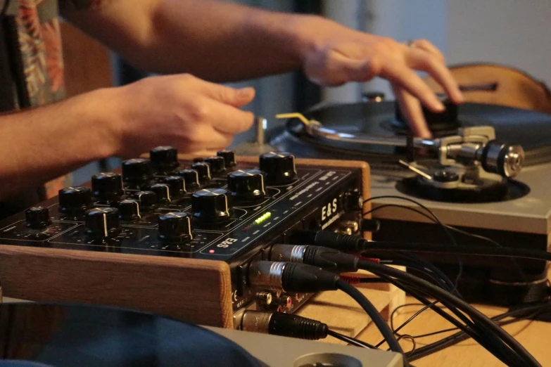 a dj works on his turntable with an equalizer