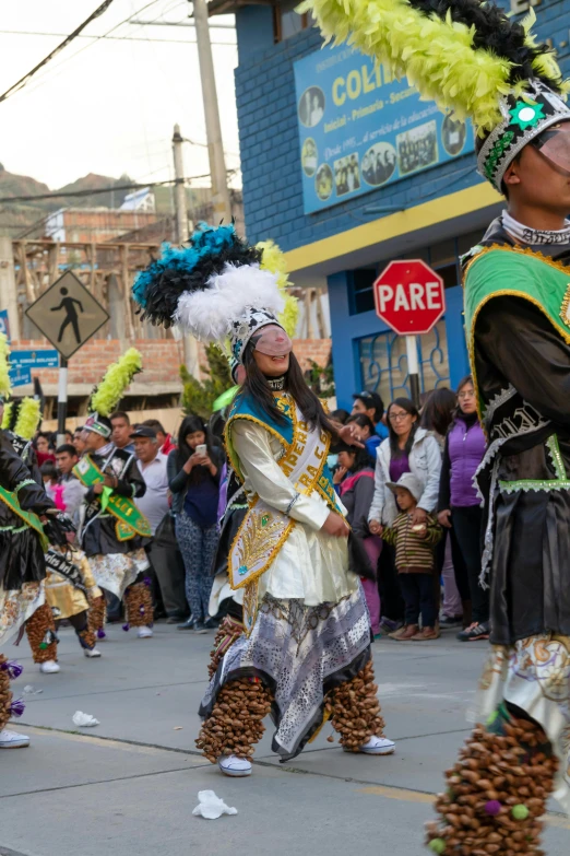 men in costume walking down the street with people watching