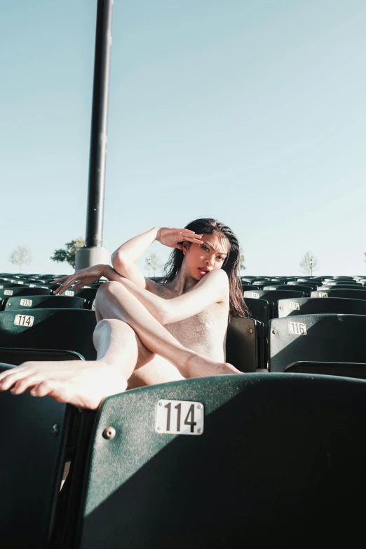 a woman sitting in the bleachers at a baseball game