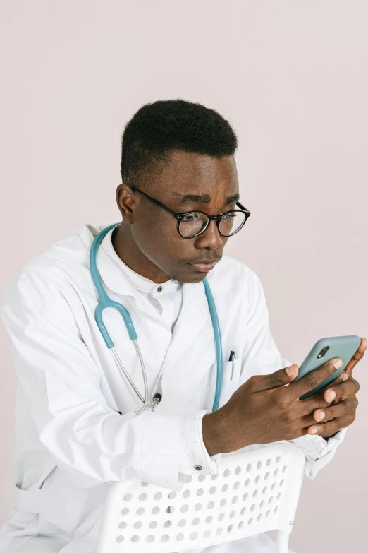 a doctor using his cellphone while sitting in a chair