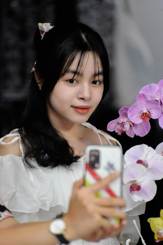 an oriental woman poses for a picture on her cell phone