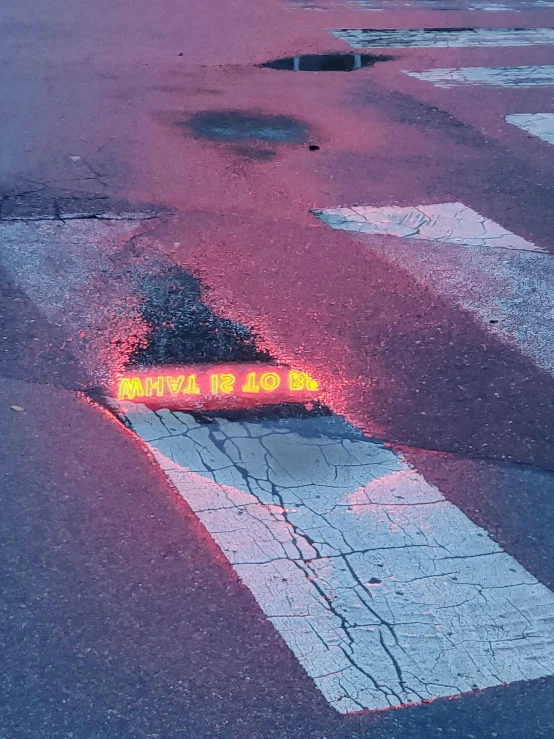 a street sign lying in the middle of an asphalt road